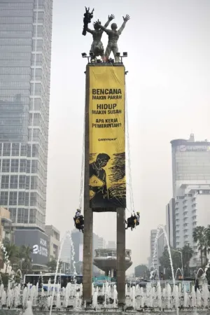 Greenpeace Bentangkan Spanduk Raksasa di Puncak Patung Selamat Datang Bundaran HI Hari Ini